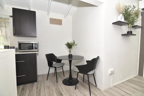 a kitchen with a table and chairs in a room at Good Stay Apartments and Car Rentals in Gros Islet