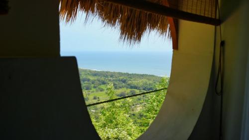 a window in a room with a view of a hill at Puerto Alto Hostel in Santa Marta