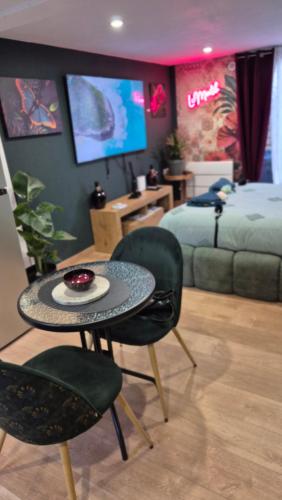 a bedroom with a table and two chairs and a bed at Studio le moutik Room du bord de mer avec SPA et sauna parking gratuit in Lampaul-Plouarzel