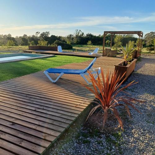 a wooden deck with a chair and a pool at Domo Tunquen in Tunquen