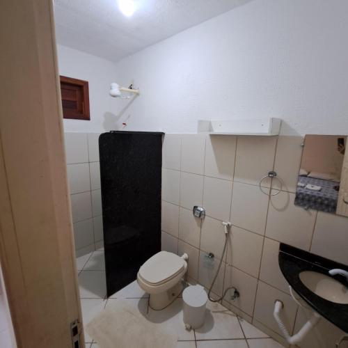 a small bathroom with a toilet and a sink at Pousada Maresias Guriri in Guriri