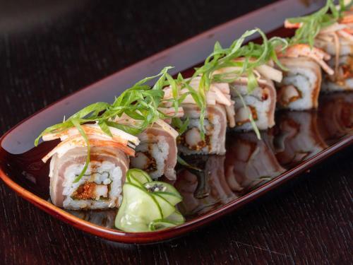 a plate of food with sushi on a table at Novotel Muscat Airport in Muscat