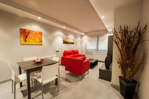 WinTuWin Apartments في ريالب: غرفة معيشة مع أريكة حمراء وطاولة