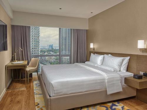 a hotel room with a bed and a large window at Novotel Suites Manila at Acqua in Manila
