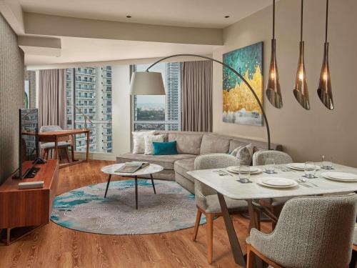 a living room with a couch and a table at Novotel Suites Manila at Acqua in Manila