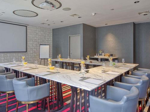 a large conference room with a long table and chairs at Novotel Suites Manila at Acqua in Manila