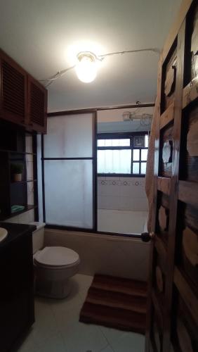 a bathroom with a toilet and a window at Casa La Carmela in Cota