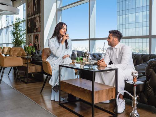 a man and a woman sitting at a table at Adagio Jeddah City Center in Jeddah
