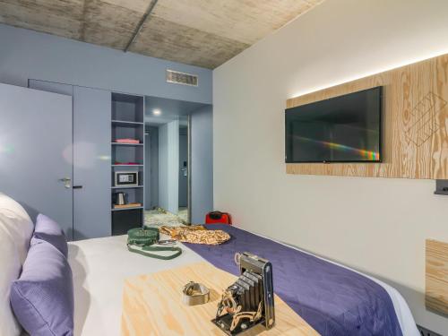 a bedroom with a bed and a tv on the wall at ibis Styles Bucharest City Center in Bucharest