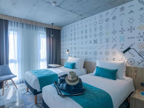 a hotel room with two beds with hats on them at ibis Styles Bucharest City Center in Bucharest