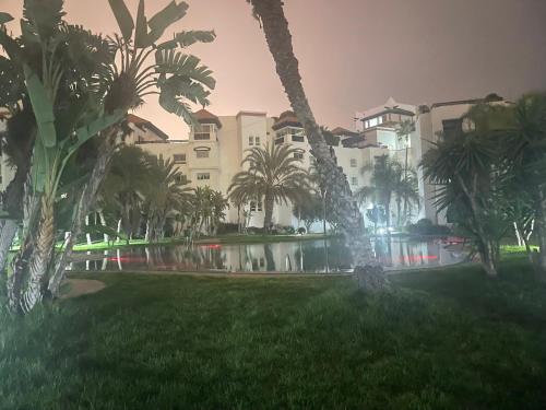 a building with palm trees in front of a pool at marina1 in Agadir