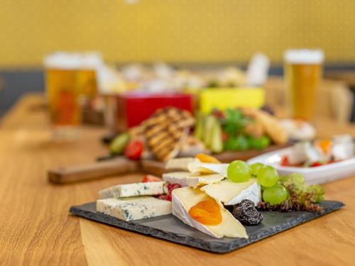 a plate of cheese and grapes on a table at ibis Styles Bucharest City Center in Bucharest