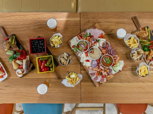 a wooden table with a bunch of food on it at ibis Styles Bucharest City Center in Bucharest