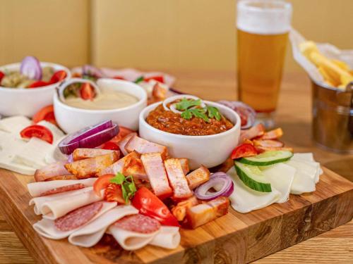 a plate of food with appetizers and dipping sauces at ibis Styles Bucharest City Center in Bucharest