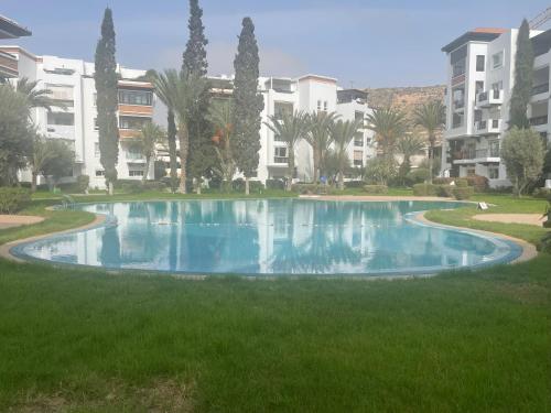 a swimming pool in the middle of a lawn with buildings at marina1 in Agadir