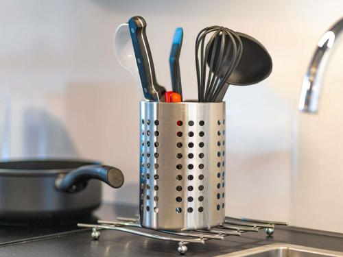 a metal container with utensils on a kitchen counter at Aparthotel Adagio Access Freiburg in Freiburg im Breisgau