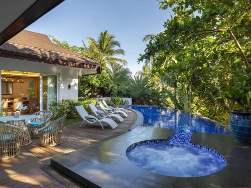 an outdoor patio with chairs and a swimming pool at Movenpick Resort & Spa Boracay in Boracay