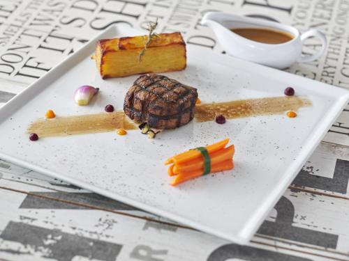 a plate of food with a piece of cake and carrots at Movenpick Resort & Spa Boracay in Boracay