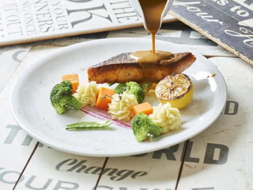 a plate of food with meat broccoli and vegetables at Movenpick Resort & Spa Boracay in Boracay