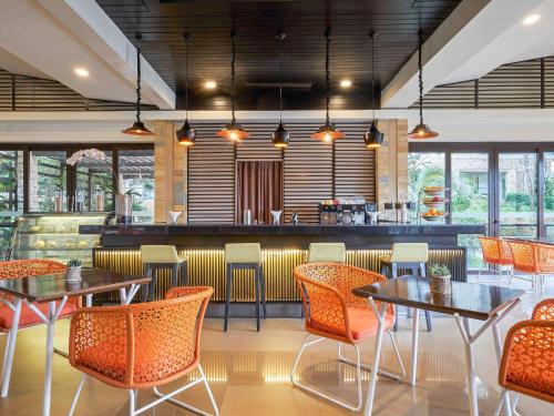 a restaurant with tables and chairs and a bar at Movenpick Resort & Spa Boracay in Boracay