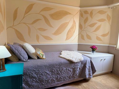 a bedroom with a bed and a wall with leaves at Paraíso na praia 800 mts do mar in Imbé
