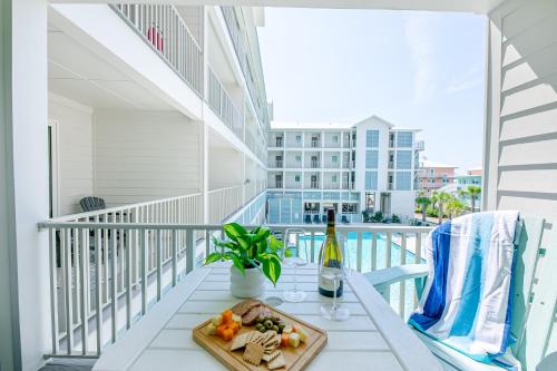 a tray of food and a bottle of wine on a balcony at Sea Glass 214 New Condo ON THE BEACH in Gulf Shores