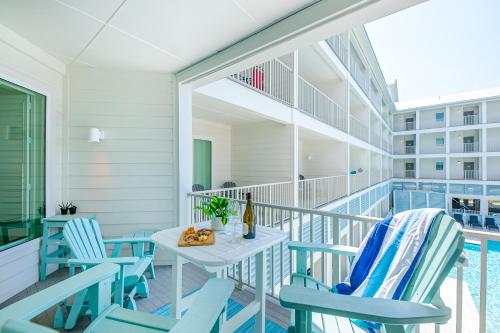 a balcony with chairs and a table and a pool at Sea Glass 214 New Condo ON THE BEACH in Gulf Shores