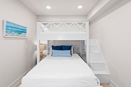 a bedroom with a white bunk bed with a blue pillow at Sea Glass 214 New Condo ON THE BEACH in Gulf Shores