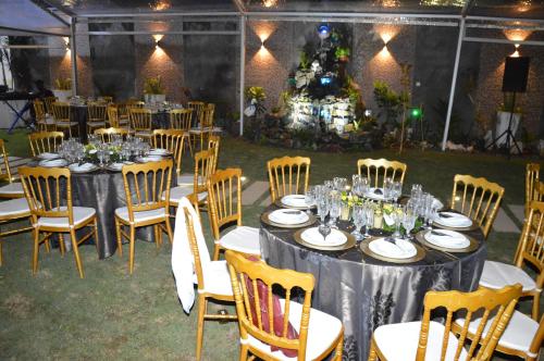 un gruppo di tavoli e sedie con piatti e bicchieri da vino di The Place a Douala