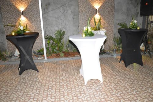 due tavoli con fiori sopra in una stanza di The Place a Douala