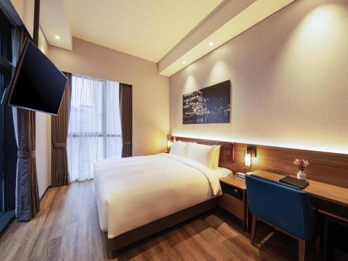 a hotel room with a bed and a desk at Mercure Ambassador Seoul Hongdae in Seoul