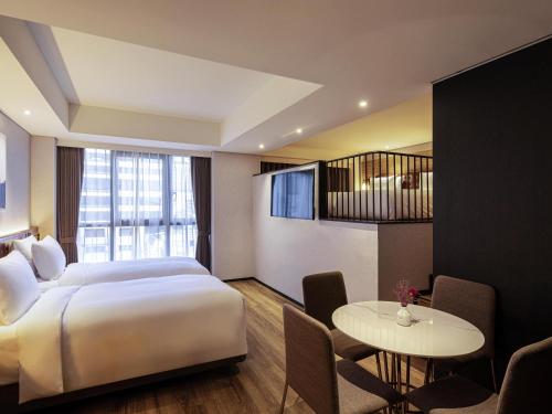 a hotel room with a bed and a table at Mercure Ambassador Seoul Hongdae in Seoul