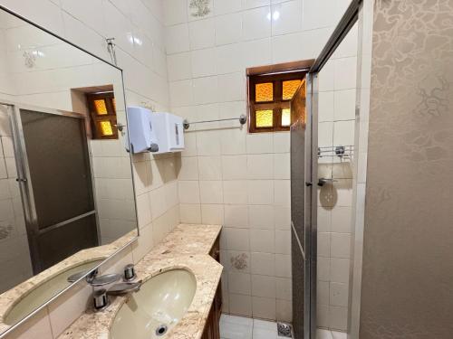 a bathroom with a sink and a shower at Hotel pousada Janaúba in Janaúba