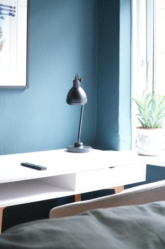 a lamp sitting on a white desk in a bedroom at Danmarksgade Ensuites in Aalborg