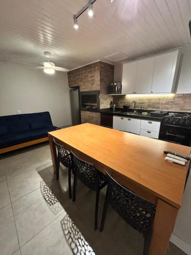 Solarium Riviera - Casa2 - NOVA 600m praia Riviera في ماتينيوس: مطبخ مع طاولة خشبية وبعض الكراسي