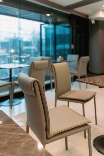 a row of chairs and tables in a room at โรงแรมริเวอร์ ซิตี้ ปัตตานี in Ban Ru Sa Mi Lae