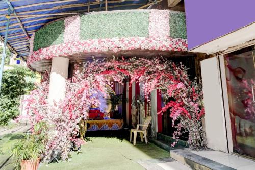 a building with a floral arch with pink flowers at Collection O Thane Formerly Dove Residency in Kolshet