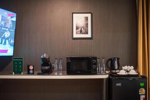 a counter in a hotel room with a microwave at โรงแรมริเวอร์ ซิตี้ ปัตตานี in Ban Ru Sa Mi Lae