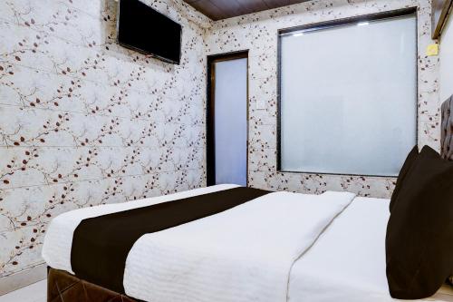 a bedroom with a white bed and a window at Collection O Thane Formerly Dove Residency in Kolshet