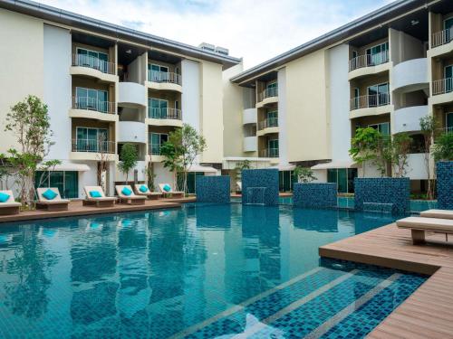 an empty swimming pool in front of a hotel at Mercure Langkawi Pantai Cenang in Pantai Cenang