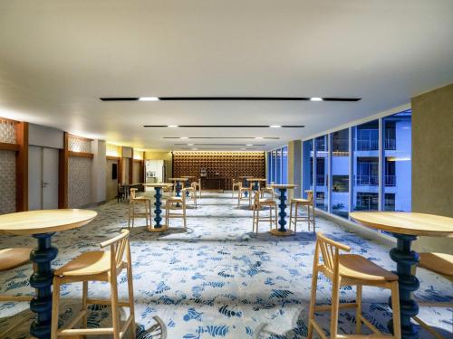 a room with tables and chairs and a room with windows at Mercure Langkawi Pantai Cenang in Pantai Cenang