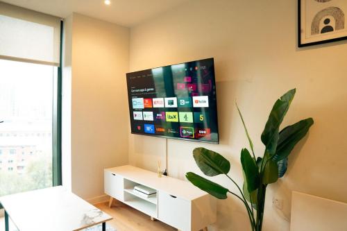 a living room with a tv on the wall at Luxury sky suites 2 bedroom 2 bathroom city centre apartment in Manchester