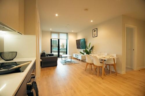 a kitchen and living room with a table and chairs at Luxury sky suites 2 bedroom 2 bathroom city centre apartment in Manchester
