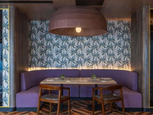 a table with two chairs and a purple couch at Mercure Jayapura in Jayapura