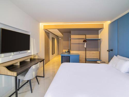 a hotel room with a bed and a flat screen tv at Mercure St. Julian's Malta in St Julian's