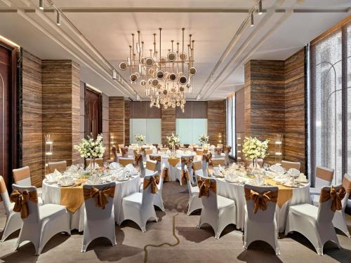 a large banquet room with white tables and chairs at Mövenpick Hotel Hanoi Centre in Hanoi