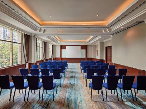 a conference room with blue chairs and a screen at Mövenpick Hotel Hanoi Centre in Hanoi