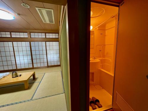 un bagno con doccia, lavandino e WC di HAKUBA GARDEN Hotel a Hakuba