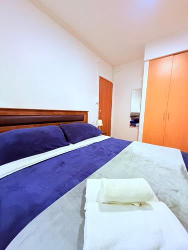 a bedroom with a large bed with blue sheets at MAKTVB Europa - Hostal Boutique in Santiago
