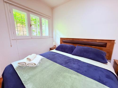 a bedroom with a blue bed with towels on it at MAKTVB Europa - Hostal Boutique in Santiago